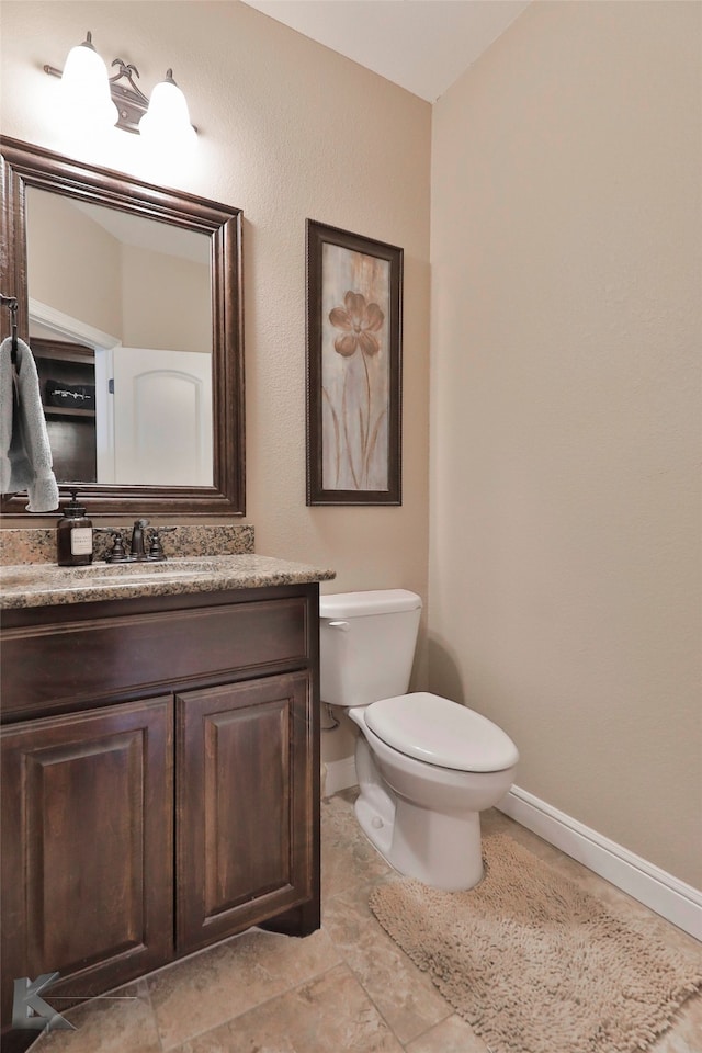 bathroom featuring toilet, tile floors, and vanity