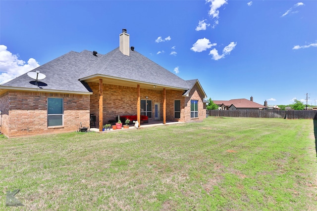 rear view of property with a patio and a yard