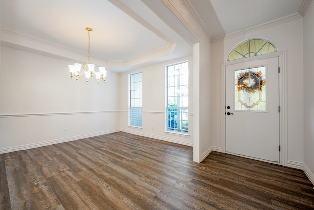 foyer with ornamental molding, dark wood-type flooring, a chandelier, and a tray ceiling