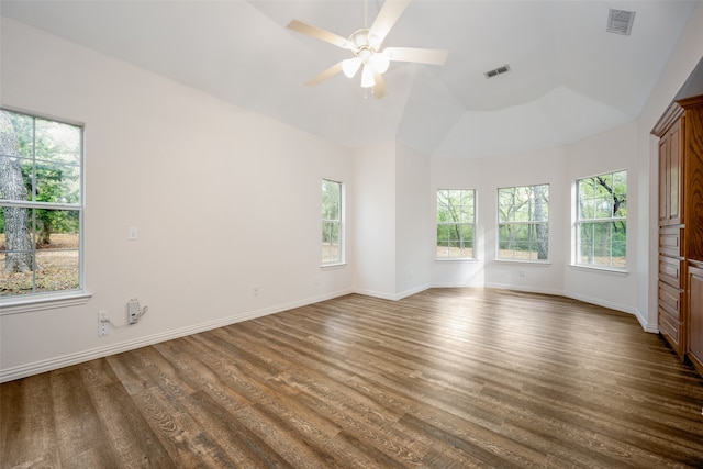 spare room with a wealth of natural light, lofted ceiling, dark hardwood / wood-style floors, and ceiling fan