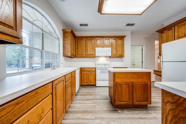 kitchen featuring white appliances, sink, and light hardwood / wood-style flooring