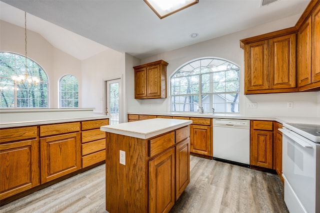 kitchen featuring hanging light fixtures, white appliances, vaulted ceiling, and a wealth of natural light