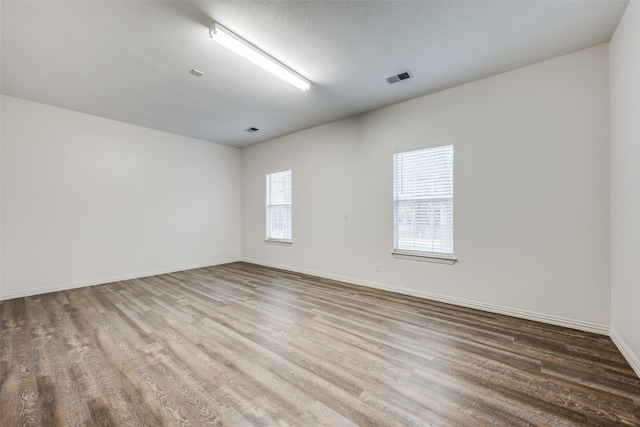 spare room with wood-type flooring and a textured ceiling