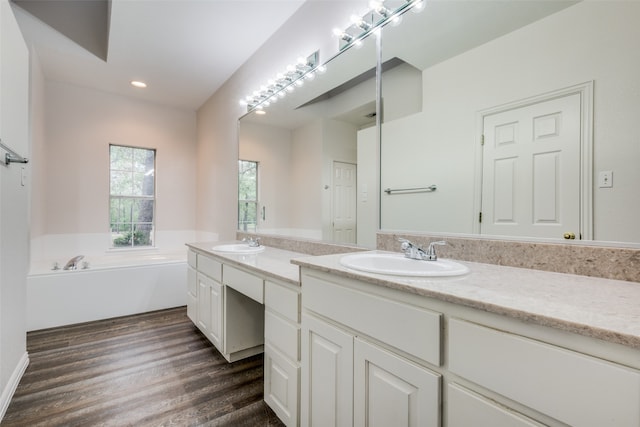 bathroom featuring hardwood / wood-style floors, vanity, and a bathing tub