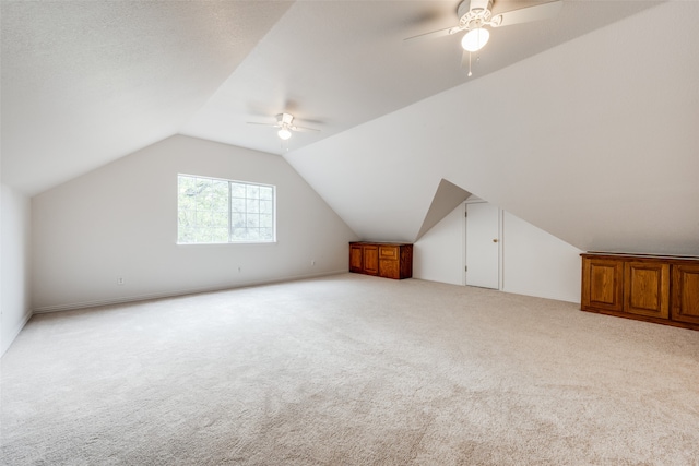 additional living space with ceiling fan, light carpet, and lofted ceiling