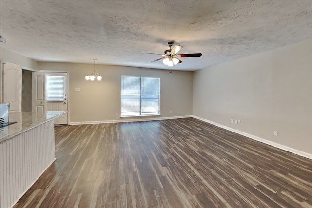 unfurnished living room with dark hardwood / wood-style flooring, ceiling fan with notable chandelier, and a textured ceiling