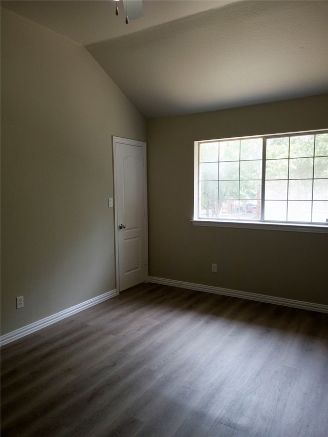 spare room with ceiling fan, vaulted ceiling, and dark wood-type flooring