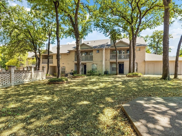 rear view of house featuring a yard and a balcony