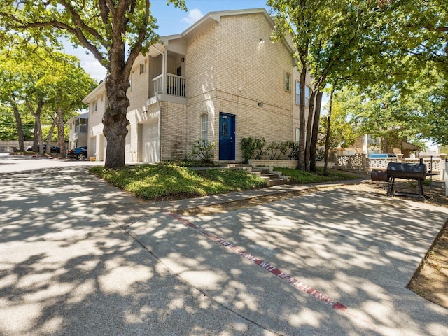 view of side of home with a garage and a balcony