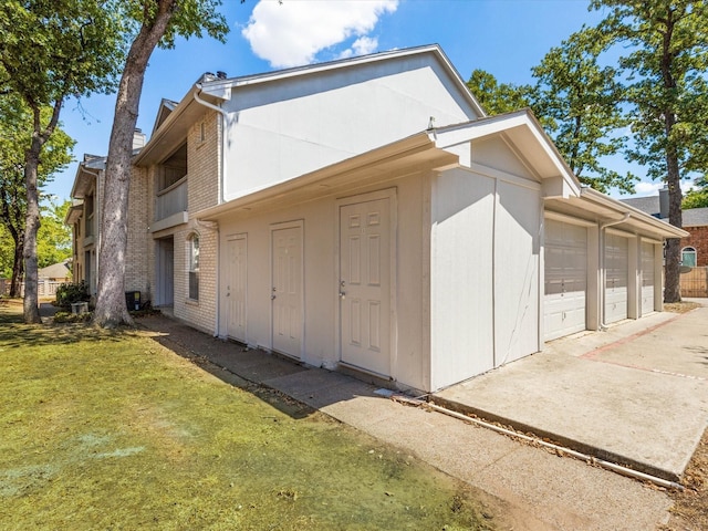 view of side of home featuring a garage and a lawn