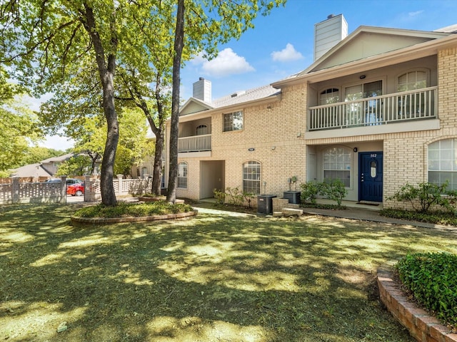 rear view of property with central AC, a yard, and a balcony