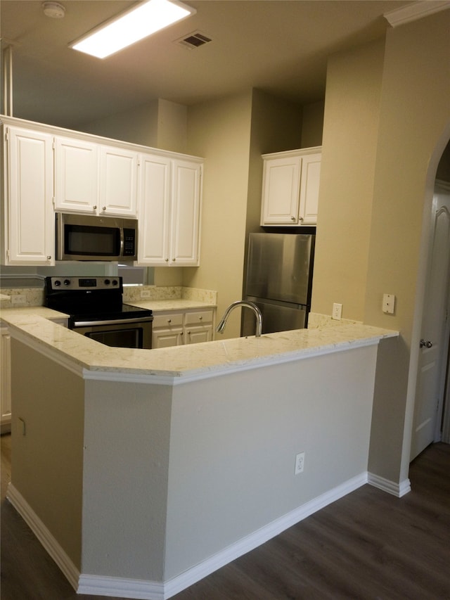 kitchen featuring appliances with stainless steel finishes, dark wood-type flooring, white cabinetry, and light stone counters