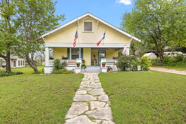 bungalow featuring a front yard and covered porch