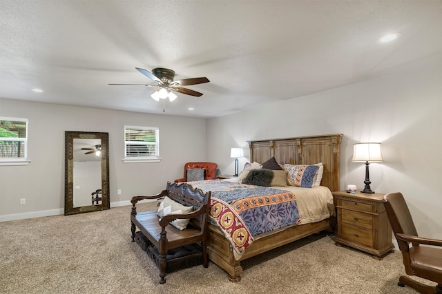 carpeted bedroom with ceiling fan, multiple windows, and a textured ceiling