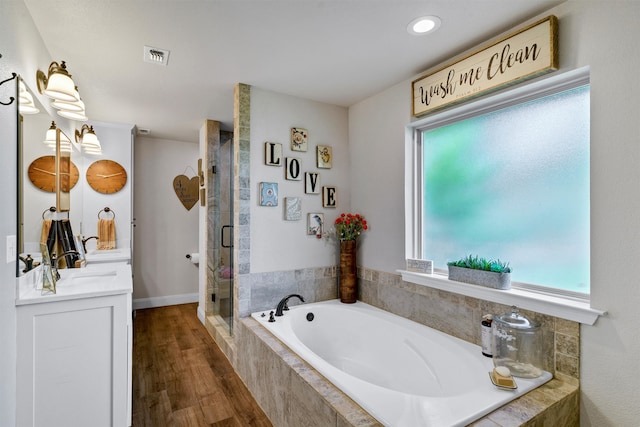 bathroom featuring hardwood / wood-style flooring, separate shower and tub, and vanity