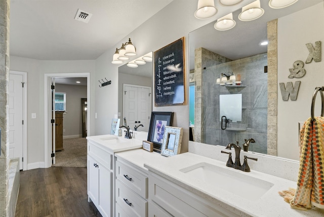 bathroom featuring walk in shower, dual vanity, and hardwood / wood-style floors