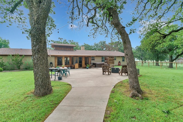 rear view of property with a patio area and a yard