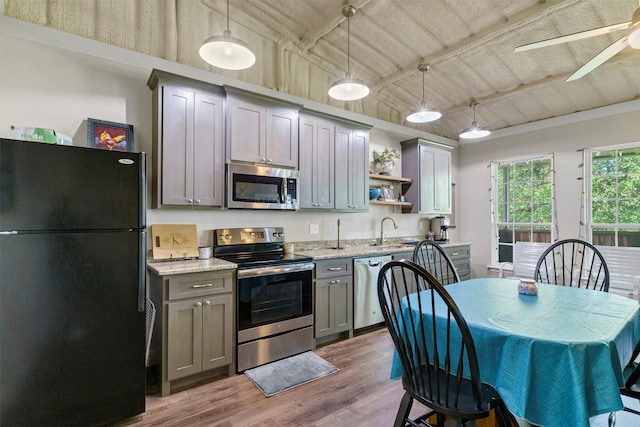 kitchen with ceiling fan, hardwood / wood-style floors, stainless steel appliances, pendant lighting, and gray cabinets