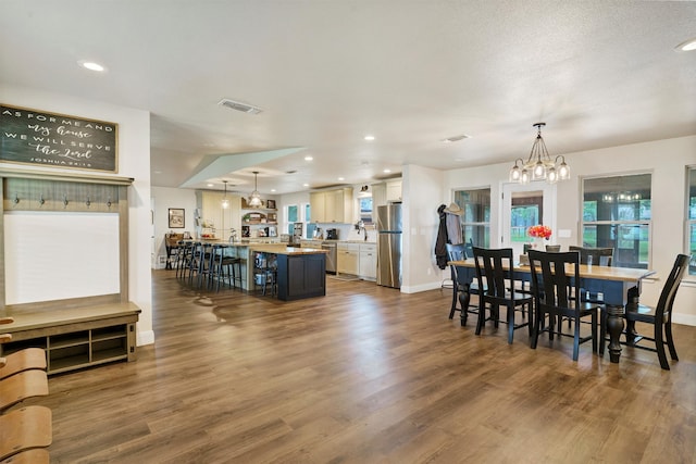 dining room with a notable chandelier, a textured ceiling, and wood-type flooring