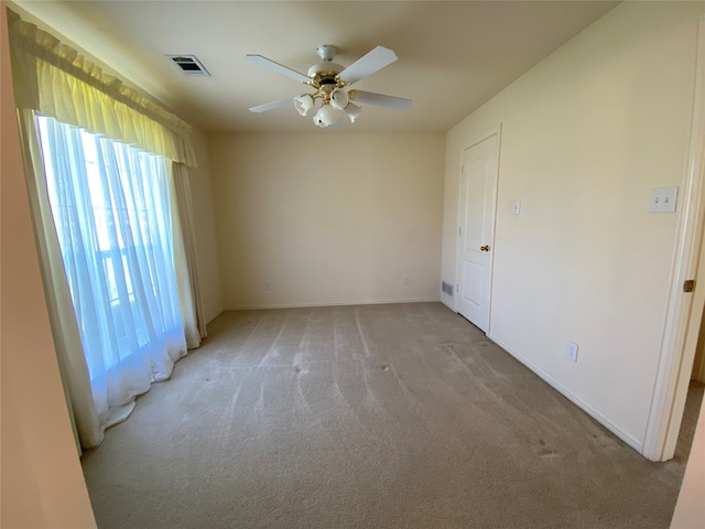 unfurnished room with light colored carpet and ceiling fan