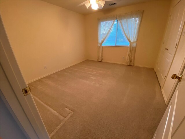 unfurnished room featuring light carpet and ceiling fan