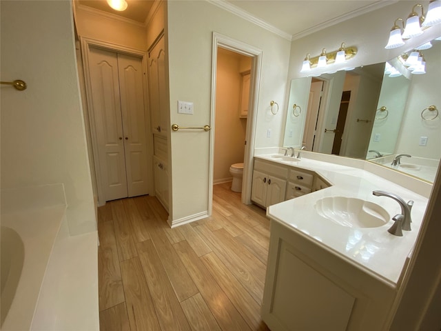 bathroom featuring double vanity, ornamental molding, hardwood / wood-style flooring, and toilet