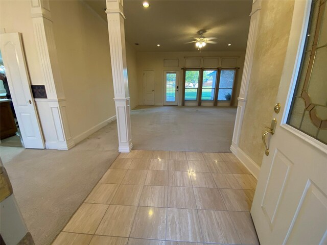 corridor featuring light tile patterned floors and ornate columns