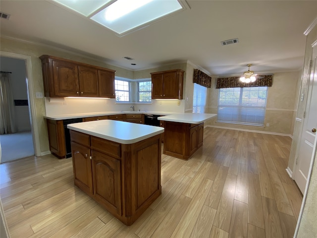 kitchen featuring black dishwasher, sink, light hardwood / wood-style floors, a kitchen island, and ceiling fan