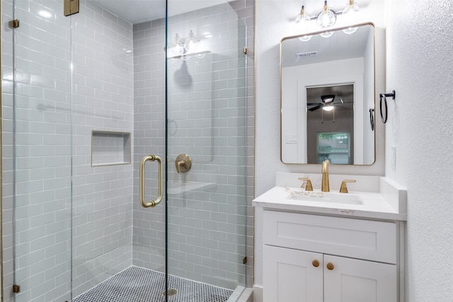 bathroom featuring walk in shower, ceiling fan, and vanity