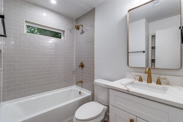 full bathroom with oversized vanity, tiled shower / bath, and toilet