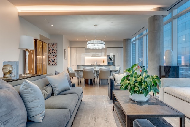 living room featuring a chandelier, light hardwood / wood-style flooring, and sink