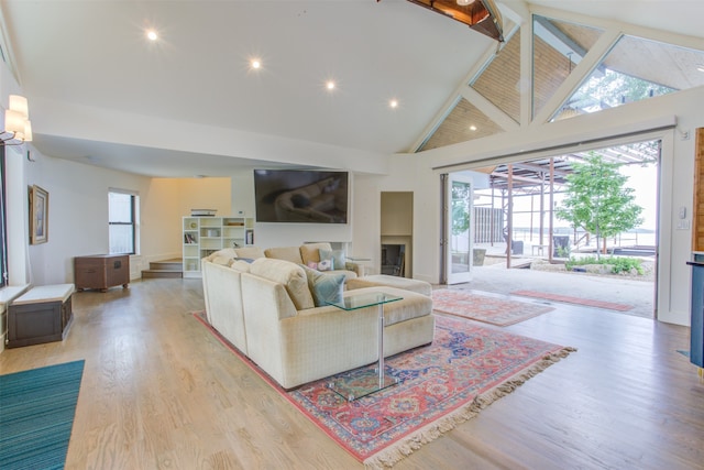 living room with high vaulted ceiling, hardwood / wood-style flooring, and beam ceiling