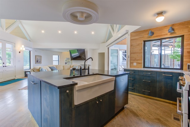 kitchen with wooden walls, a breakfast bar, light wood-type flooring, high quality appliances, and a kitchen island