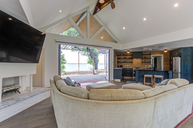 living room featuring wooden walls, a premium fireplace, dark hardwood / wood-style flooring, and high vaulted ceiling