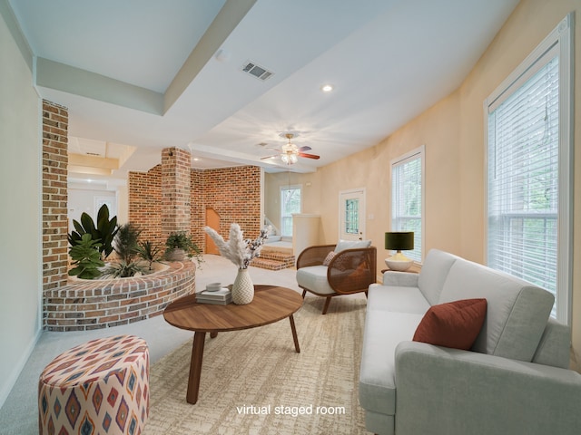 living room featuring brick wall, carpet floors, and ceiling fan