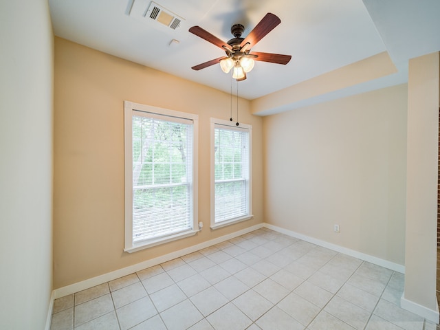 tiled spare room featuring plenty of natural light and ceiling fan