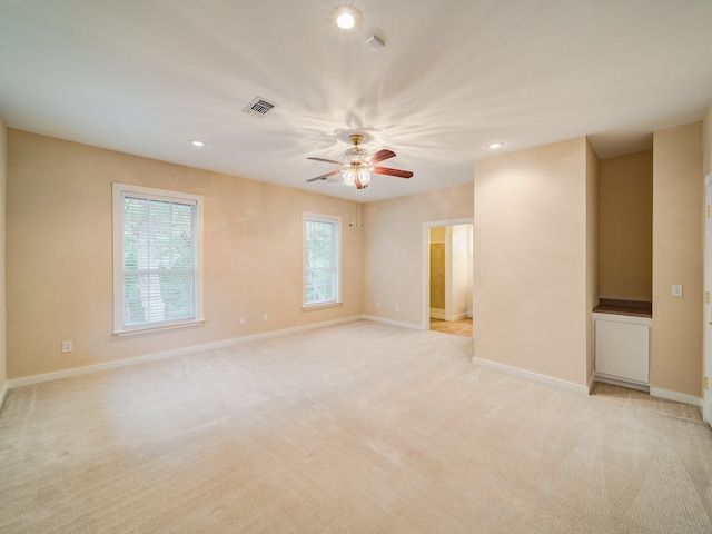 unfurnished room with light carpet, plenty of natural light, and ceiling fan