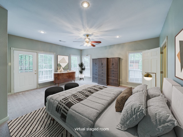 carpeted bedroom with ceiling fan and multiple windows