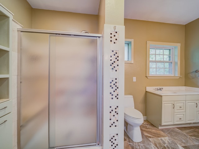 bathroom with vanity, toilet, tile floors, and a shower with door