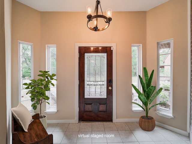 foyer entrance with a wealth of natural light, a notable chandelier, and light tile flooring