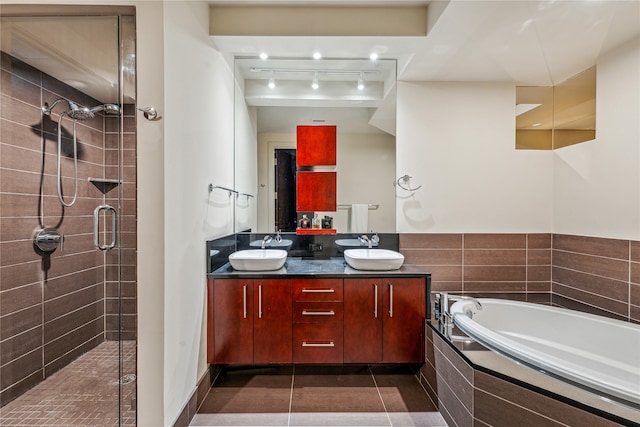 bathroom with tile flooring, vanity with extensive cabinet space, separate shower and tub, and double sink