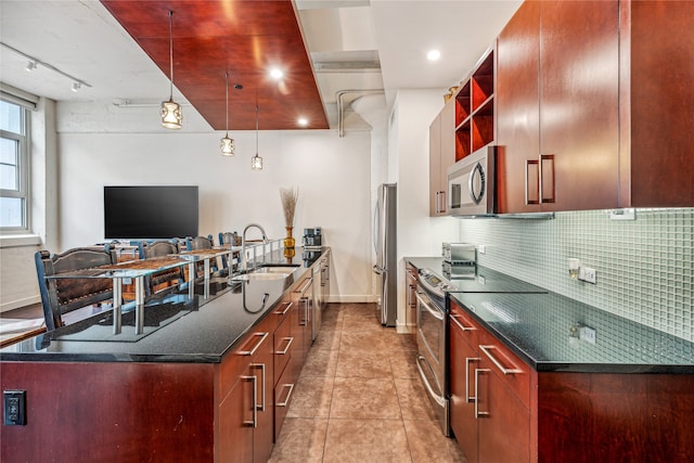 kitchen with light tile floors, sink, backsplash, stainless steel appliances, and dark stone countertops