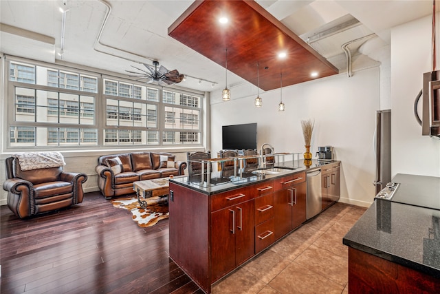 kitchen with appliances with stainless steel finishes, ceiling fan, sink, tile floors, and dark stone countertops