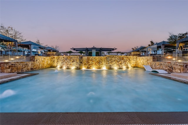 pool at dusk with pool water feature