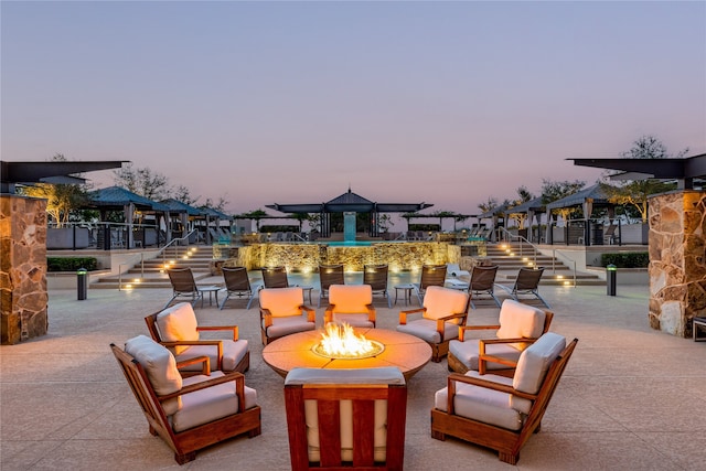 patio terrace at dusk featuring an outdoor fire pit