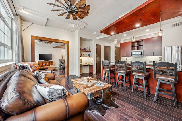 living room featuring ceiling fan and dark hardwood / wood-style flooring