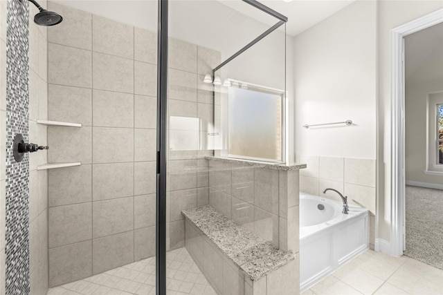 bathroom with tile patterned floors and shower with separate bathtub