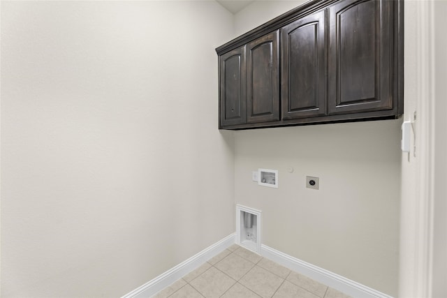 laundry room featuring electric dryer hookup, cabinets, gas dryer hookup, hookup for a washing machine, and light tile patterned floors