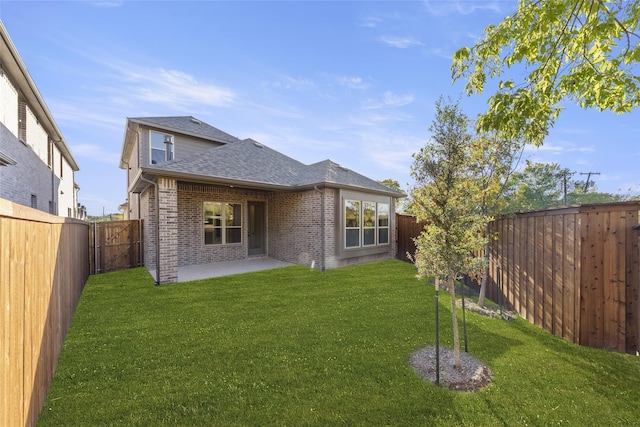 rear view of house featuring a yard and a patio