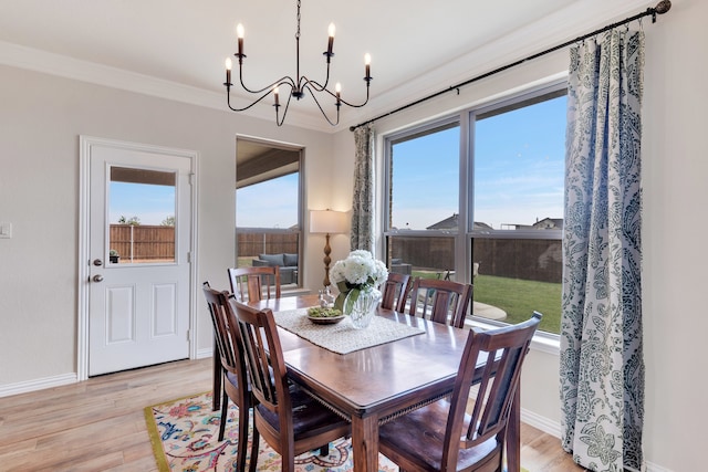 dining room with crown molding, a notable chandelier, and light wood-type flooring